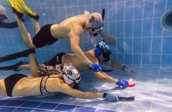 In this photo taken on February 15, 2017, members of the &quot;HK Typhoon&quot; underwater hockey club fight for possession of the puck (right), during their once-a-week team practice session at a 25-meter school pool in Hong Kong. The gravity defying sport of underwater hockey has gained a worldwide following -  now a Hong Kong team is diving in as the game takes off in Asia. (games)